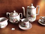 five pieces of porcelain tea set on a brown cloth