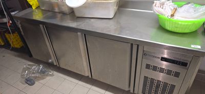 stainless steel counter top in a commercial kitchen with two bowls of food on it