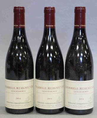trois bouteilles de vin rouge sont alignées sur une table