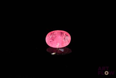 La boule rose brille dans le noir et sa surface reflète la lumière.