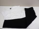 white shirt and black pants sitting on top of a white table