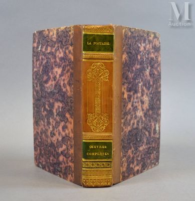 un vieux livre posé sur une table à côté d'un mur blanc