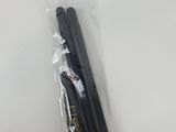 deux stylos noirs se trouvent dans un sac en plastique posé sur une surface blanche