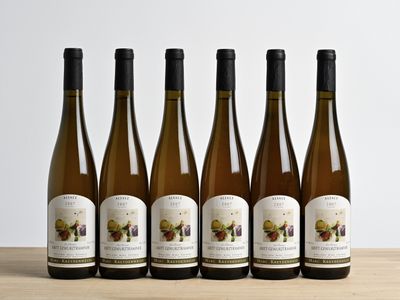 six bouteilles de vin sont alignées sur une table en bois