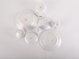 a lot of white plates and cups on the table