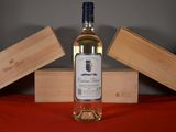 a bottle of wine sitting on a table next to a wooden box