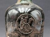 a very old bottle that is sitting on a table