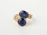gros plan d'une bague en saphir bleu et diamant sur une surface blanche