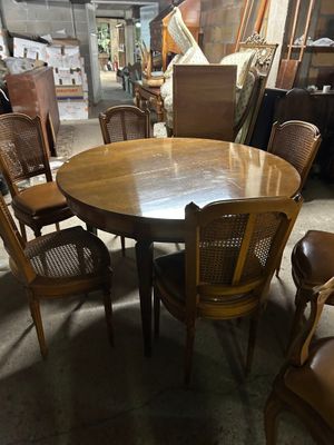 de nombreuses chaises disposées autour d'une table ronde dans un entrepôt