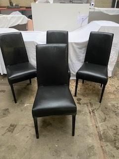trois fauteuils en cuir noir placés devant une table blanche