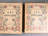 two old books are sitting side by side on a table