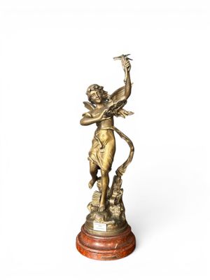 a bronze statue of a woman holding a bird on top of a wooden base