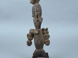une petite statue représentant un homme avec un oiseau sur la tête