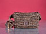 an image of a purse on a table with a pink background
