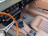 a dashboard and steering wheel of a car with a brown leather seat