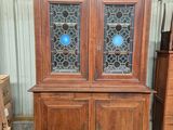 une armoire en bois surmontée de deux portes vitrées