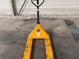 un chariot élévateur jaune garé dans un garage, à côté d'une porte de garage