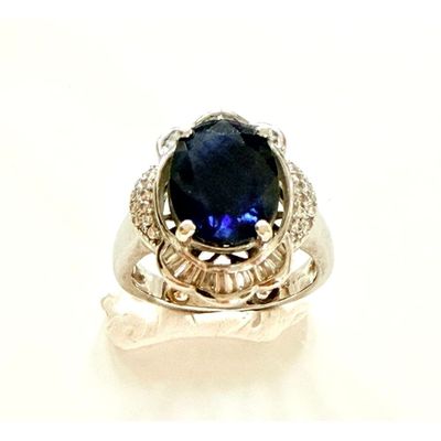 une image d'une bague avec une pierre bleue entourée de diamants