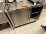 une cuisine en inox avec un évier et un grille-pain posé sur le plan de travail