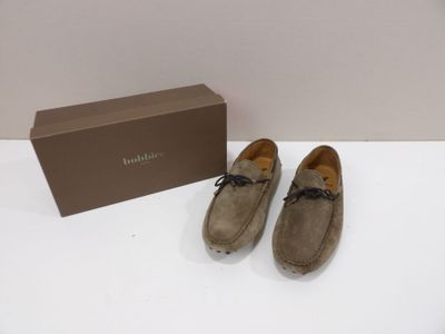 une paire de chaussures posée sur une table, à côté d'une boîte