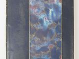 a close up of a book with a blue cover on a white surface