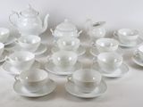 un grand nombre de tasses et de soucoupes sur une table