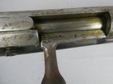 a close up of a gun with a wooden handle