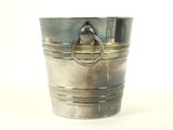 a metal bucket with a ring on it on a table