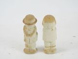 two figurines of two people standing next to each other