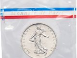 a close up of a coin in a plastic bag on a white background