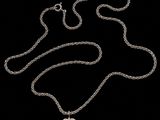 a close up of a heart shaped pendant on a chain