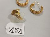 trois paires de boucles d'oreilles en or et une bague posées sur un fond blanc