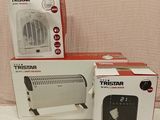 three boxes of a small heater sitting on top of a white table