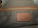 a close up of a handbag with a leather tag on it