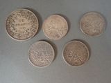 four different types of coins are shown on a gray surface