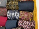 many different ties in a yellow box on a table