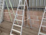 several ladders leaning up against a brick wall in a warehouse