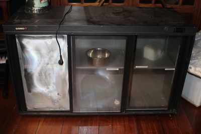 une armoire métallique dotée d'une porte vitrée et d'un bol métallique posé dessus
