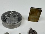 a small metal box and a lighter on a table