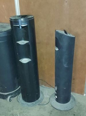 trois tuyaux noirs placés les uns à côté des autres dans une pièce