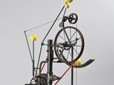 an image of a sculpture of a spinning machine with yellow balls on it
