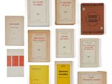 Plusieurs livres sont disposés sur une surface blanche ; leurs couvertures sont rouges et jaunes.
