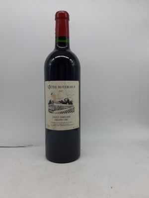la bouteille de vin rouge est posée sur une surface blanche