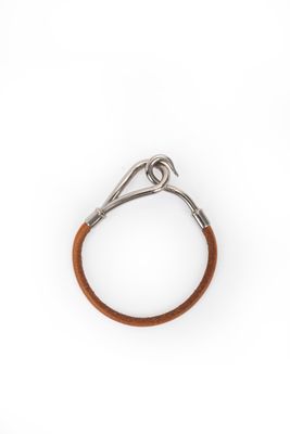 un gros plan d'un bracelet en cuir marron sur fond blanc