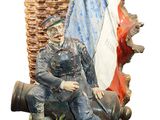 a statue of a man sitting on a bench with a basket on it
