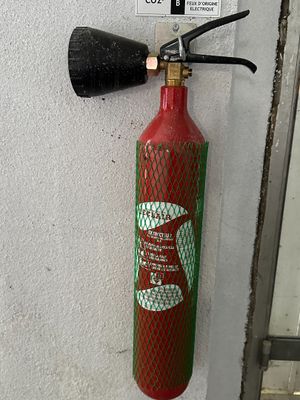 un extincteur fixé au mur d'un immeuble