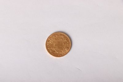 a gold coin on a white surface with a white background