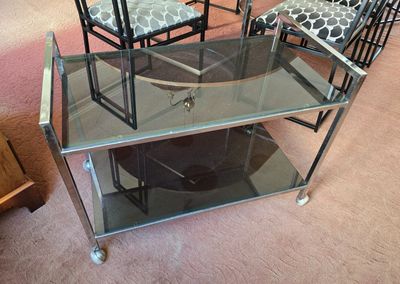 une table et des chaises en verre dans une pièce recouverte d'une moquette rose