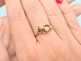 woman ' s hand with red manicured nails and a gold ring