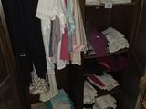 une photo montrant une armoire remplie de vêtements et une chaise